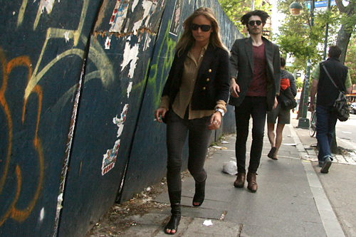 couple walk along construction fence in williamsburg brooklyn