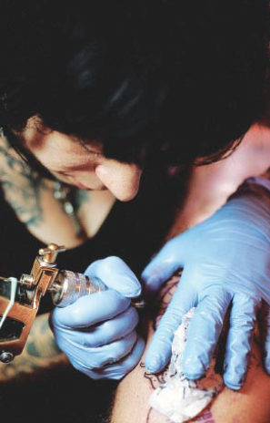 Sue Jeiven, tattoist at East River Tattoo, using a coil tattoo machine, the main tool of the trade. Photo by Sofia Faga